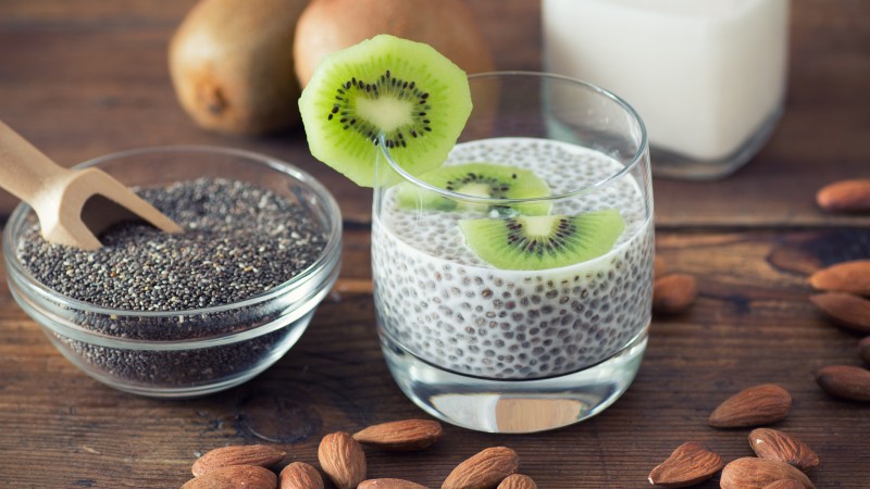 Black and white organic chia seeds forming a gel in water, demonstrating soluble mucilage fiber gut hydration properties.